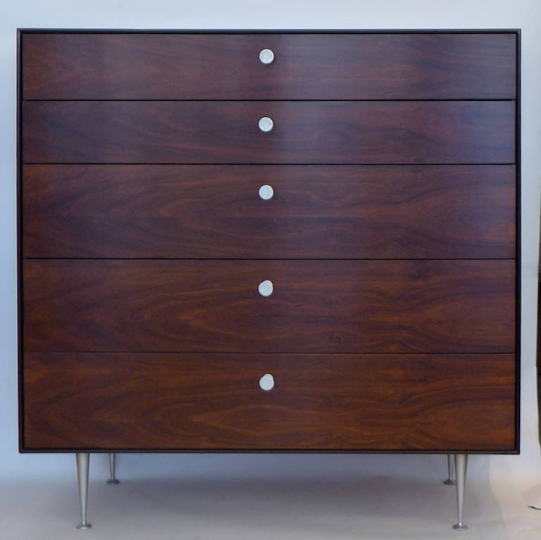 Exquisite pair of matched rosewood Thin Edge series dressers with porcelain pulls and aluminum legs in excellent condition. One retains the original label. All original dividers in drawers are present. Completely functional as well as beautiful.