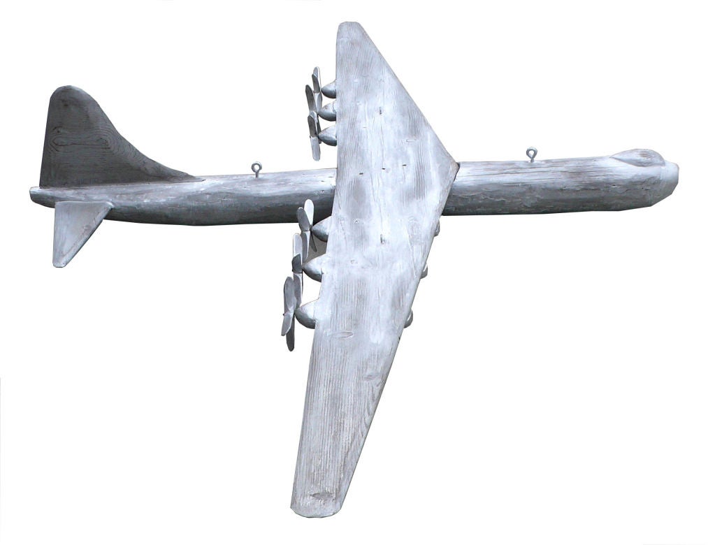 This is a huge 8' wide, hand-carved model of a B-36 Peacemaker bomber. It was carved by hand from solid hard wood and assembled by a former WW2 pilot in 1949. He attached four large eye hooks for hanging. The propellers spin freely.