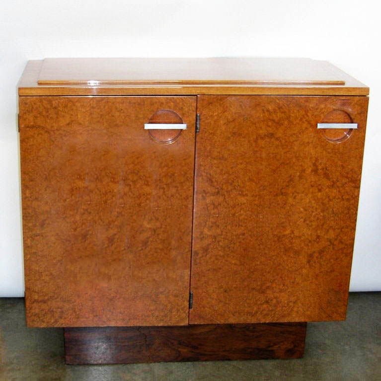 These beautiful servers were designed by Gilbert Rohde for Herman Miller in 1937. They have maidou burl door fronts, mahogany tops and sides and rosewood bases. These servers have been refinished in a beautiful hand polished high gloss lacquer