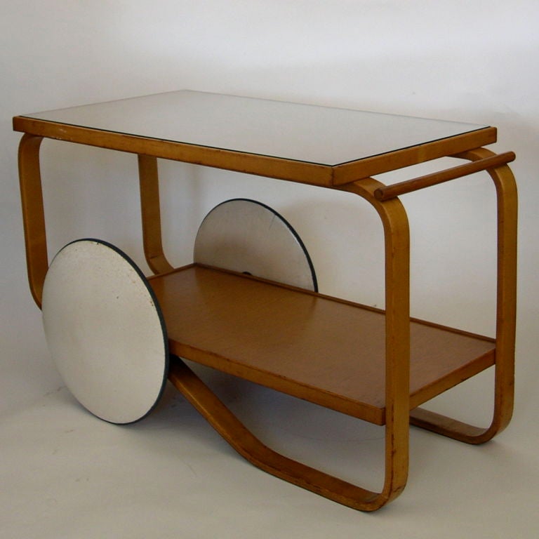 This is an excellent original example of the Alvar Aalto Tea Trolley model # 98. It has it's original patinated finish on the wood and it's original patinated lacquered wheels. It shows it's gently used age, yet is very sturdy.