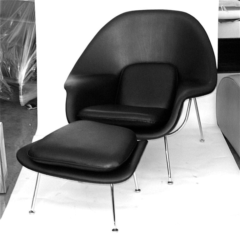 This iconic 1950's Womb chair has been expertly restored. The black leather is hand stitched and the old foam has been replaced. The chrome is excellent. The ottoman measures 16