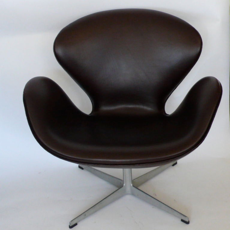 These original swan chairs are covered in vintage deep chocolate brown leather. They have the Fritz Hansen logo and 