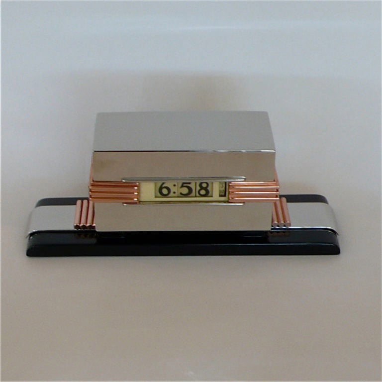 This extremely rare clock has all of the 1930's design elements in one fantastic package. The streamline black lacquered base is accented by rolled chrome bands with small tubular copper accents. These copper accents are repeated on the chrome face