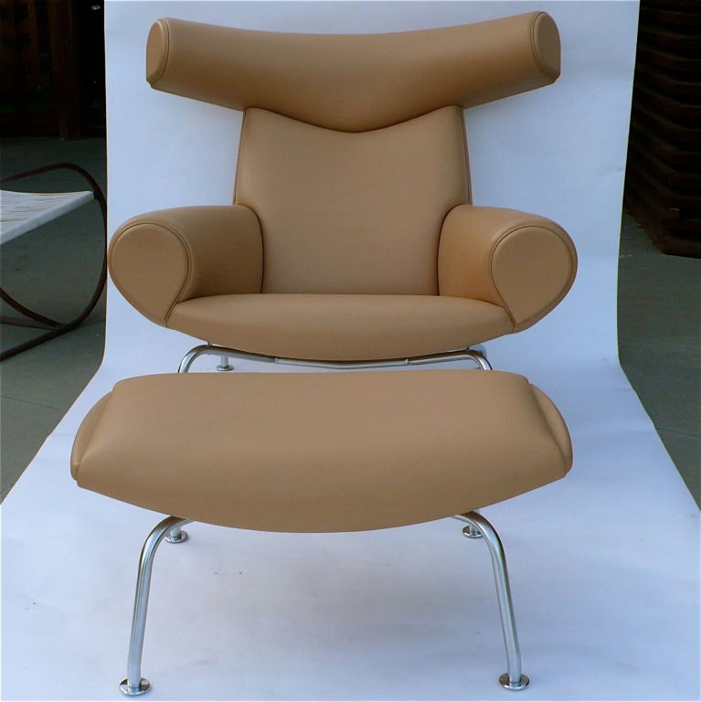 Designed in 1960 by Hans Wegner, the ox chair and ottoman is a classic sculpturally designed unit of furniture. This set, produced in 1985, by Erik Jorgensen is upholstered in camel leather. It is in excellent, virtually unused condition.
