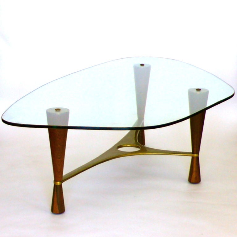 This is an extraordinary designed table by Edward Wormley for Dunbar.  It is made of rosewood, cast brass and glass. Completely original, the brass has acquired a mellow patina over the years. The original glass retains a few surface scratches  from