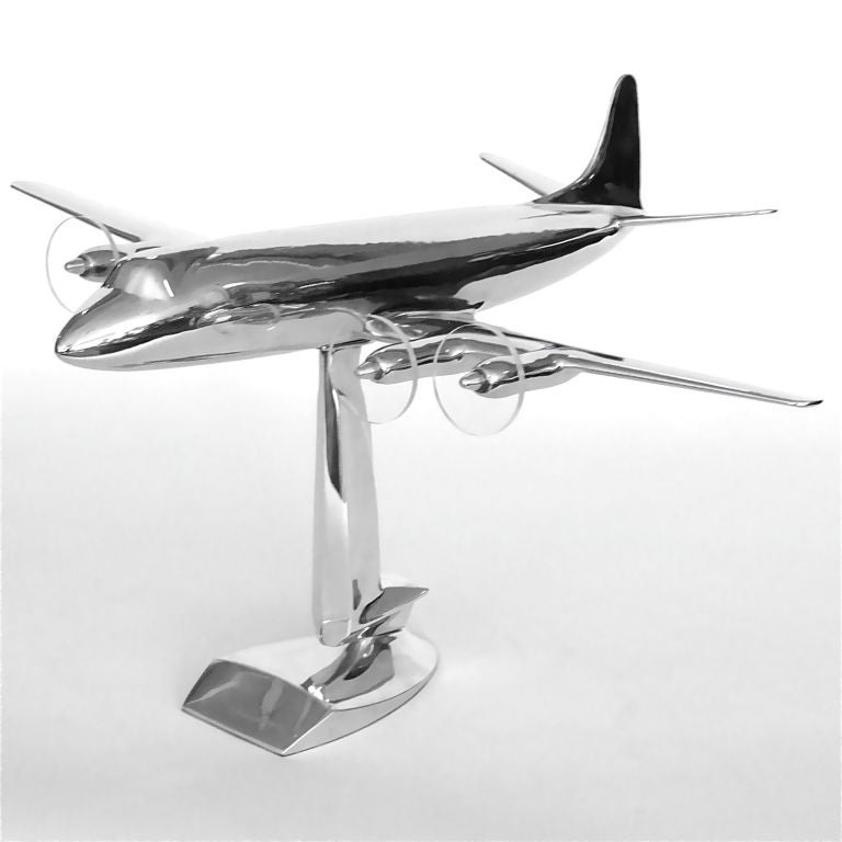 This is a very rare 1957 scale model aluminum Lockheed Electra. It was a promotional table top airplane made by Lockheed to promote it's latest model. It has it's original sculptural abstract soaring eagle base and 4 lucite propellors. This model