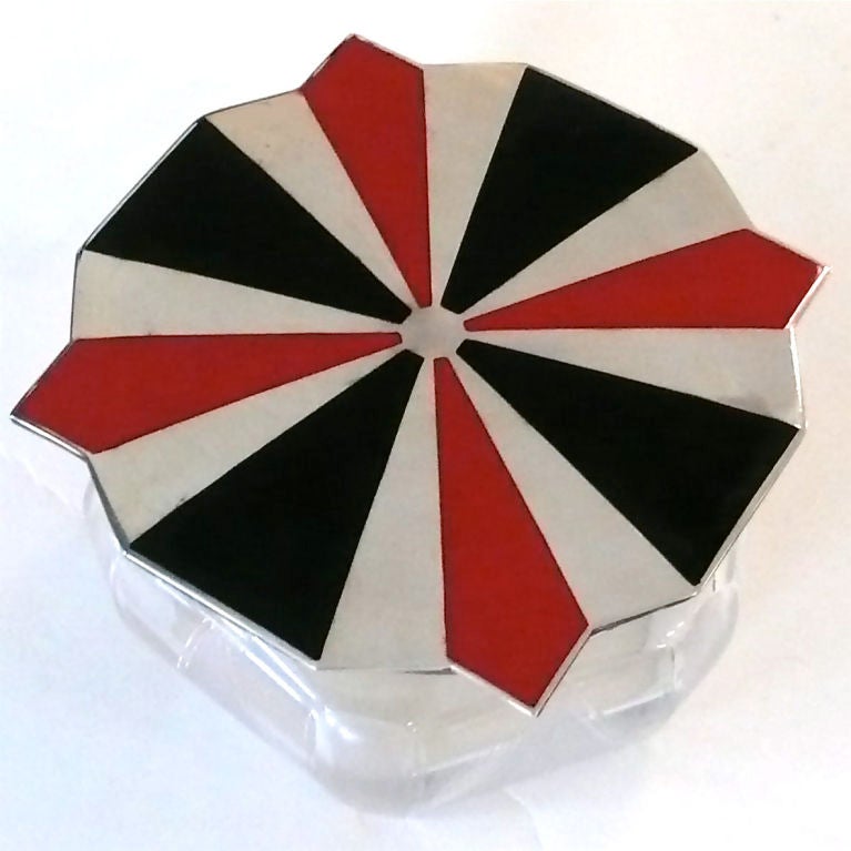 This beautiful Art Deco container would make a great vanity or tabletop accessory. The multifaceted crystal bottom has etched pyramid designs on the sides. The bold red and black enamel Art Deco designed lid is marked sterling.