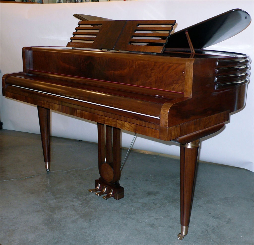 This full 88 key Wurlitzer Butterfly Pianos has the wonderful streamline art deco detailing. The design of the music stand mimics the streamline banding. The design of the wood that backs the pedals has great art deco detailing as well. The flame