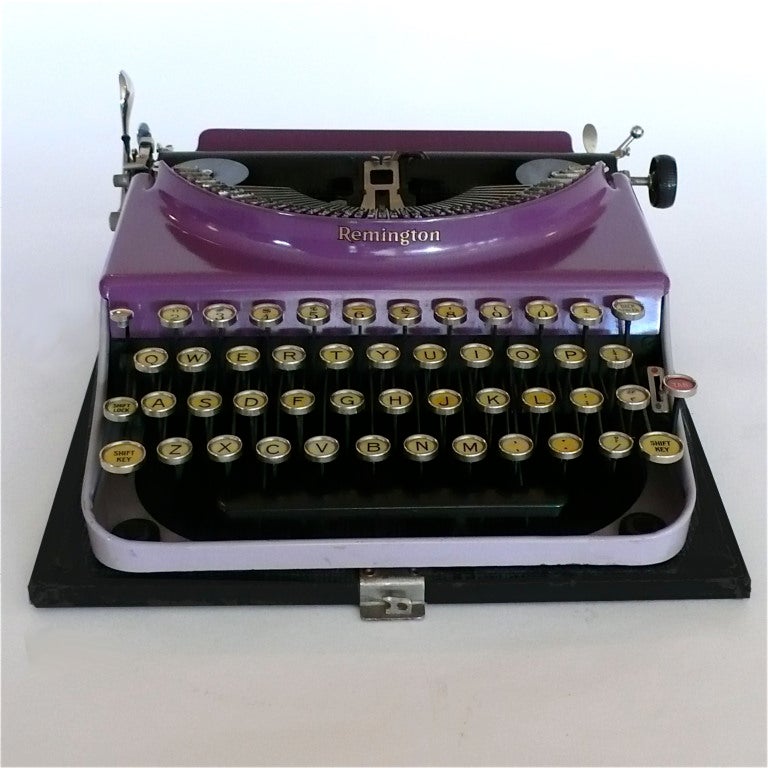 This rare original portable purple Remington typewritter is in great condition. It has a black top with a handle that attaches to the base for carrying.
