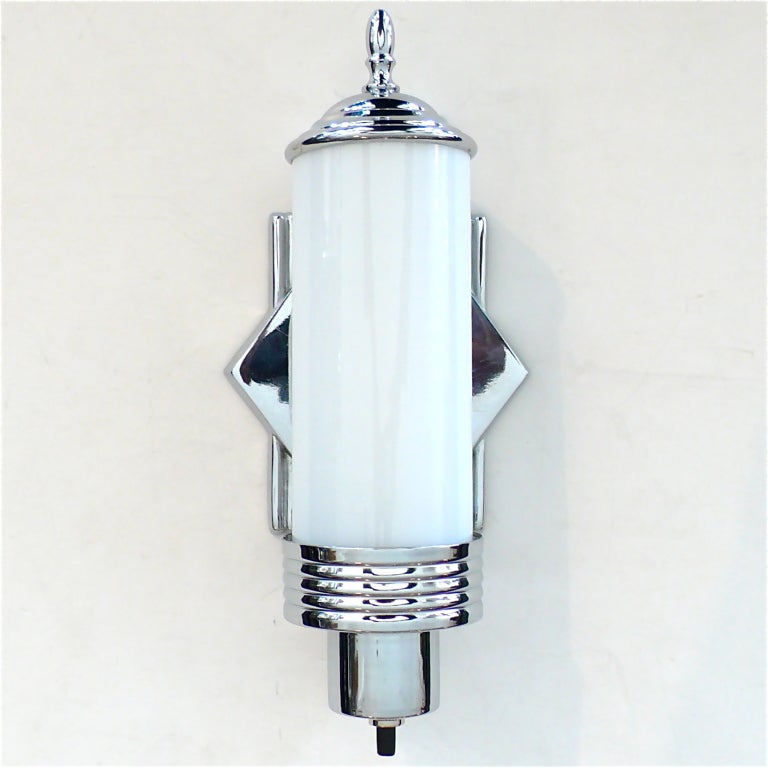 This is an excellent original pair of Art Deco Sconces. The chrome frames hold the original white glass inserts. They are really clean with great style.