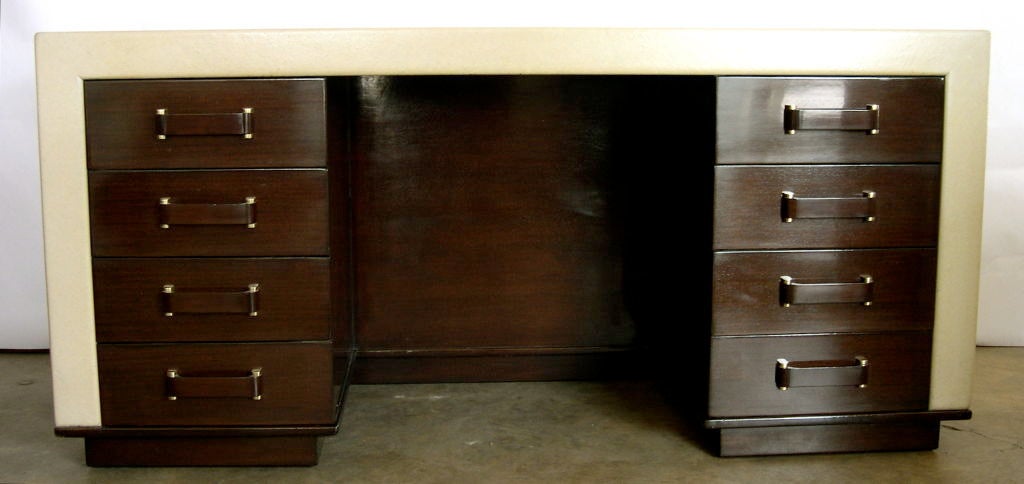 This is a great, rare Paul Frankl desk. It is parchment colored lacquered cork and dark brown mahogany. The contrast of tones and materials is very exciting. The recessed bookshelf and recessed mahogany base create a feeling of a floating form, much