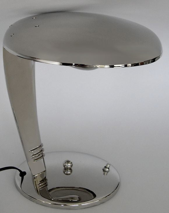 This sleek classic lamp has been restored in a beautiful polished nickel finish. The light bulb is hidden by the reflector shade which causes the light to shine upward and reflect downward from the underside of the top. This lamp gives off a strong