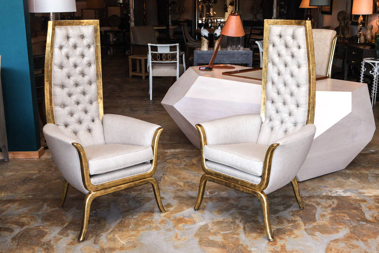 Pair of restored Mid-Century James Mont style high back armchairs in 22-karat gold and upholstered in tufted linen.  Restored, almost new condition with new tufted linen upholstery, 22K gold finish over wood. Seat 20h,17d, 12-18.5w. Upright seat