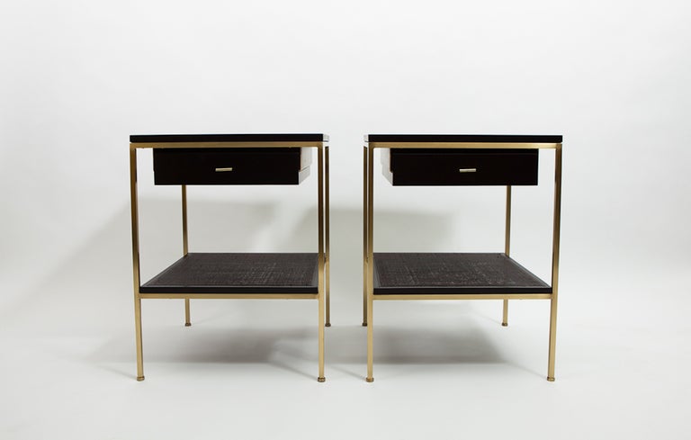 ReGeneration ebonized wood bedside tables with brass frames and caned shelves. Pop artist, Dylan Egon, has gold leafed the tops with his signature icons.