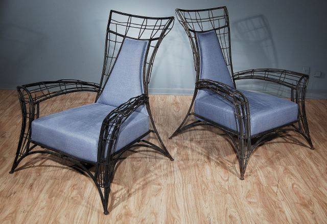 Each with an upholstered backrest, the outscrolled armrests, above the upholstered seat, raised on splayed legs.