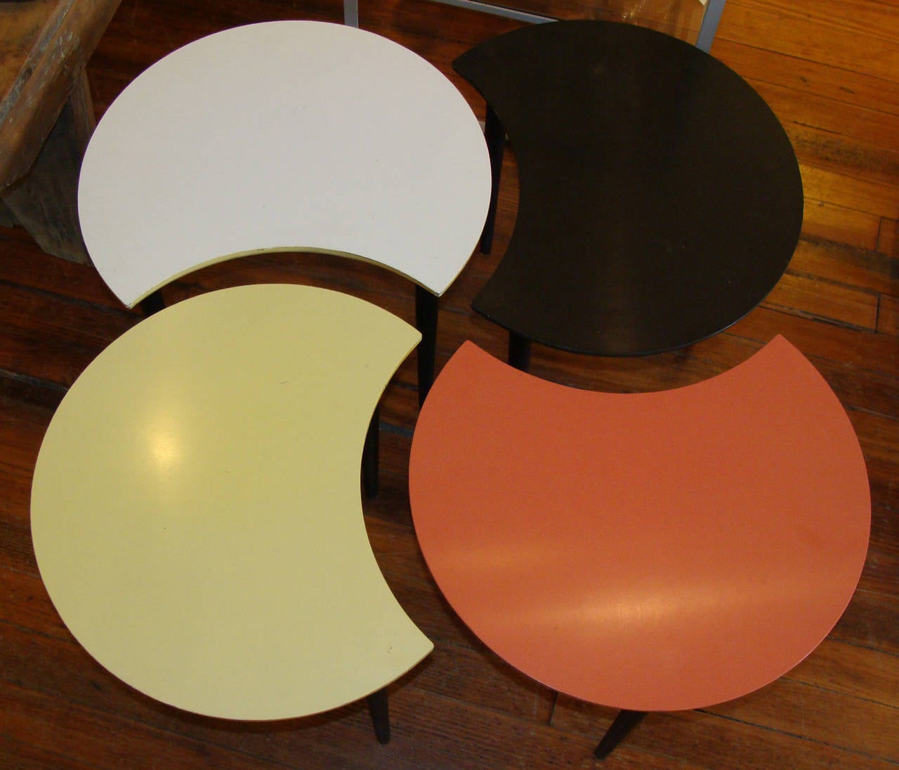 Set of four low tables which can be formed or separated in a variety of configurations.
One each in black, white, coral/orange, and yellow laminate on wood. All have black painted wood legs.
Legs can be easily unscrewed for transport/shipping.