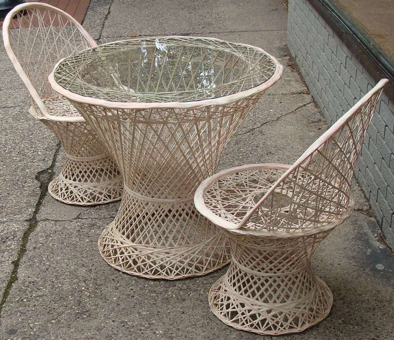 Three piece set in spun fiberglass and resin.  Can be used outdoors.  Lacks seat cushions.  Clear glass top.

Offered  as a three-piece set. Dimensions given below are for table only.
