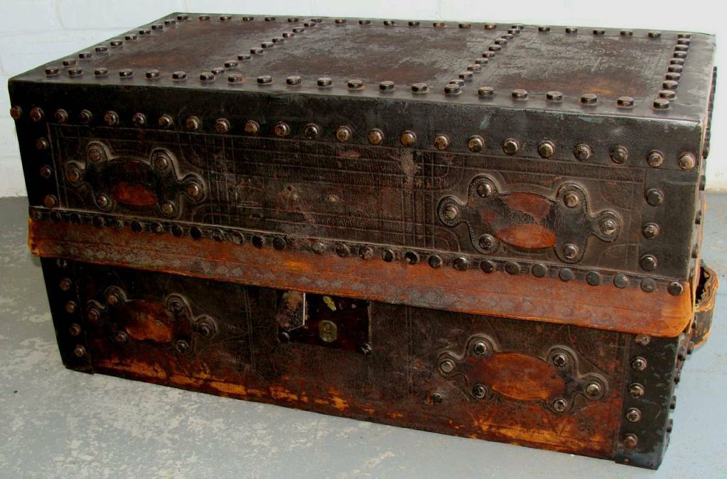 Unusual compact-sized trunk. Leather covering with metal trim and wonderful metal studs. Probably French origin. Early print of 