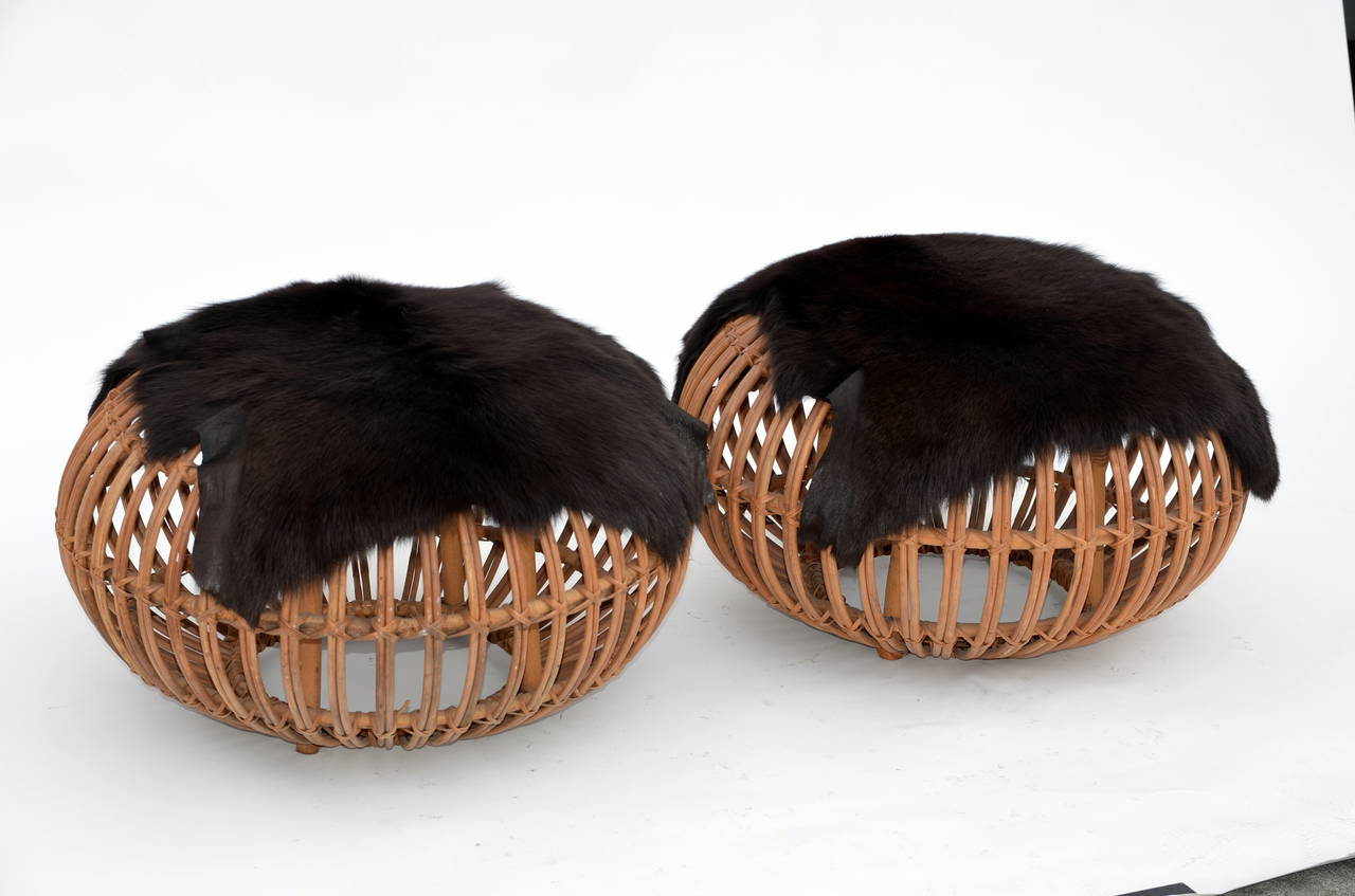 Pair of Round Rattan Ottomans in the style of Franco Albini with Fur Covers.
