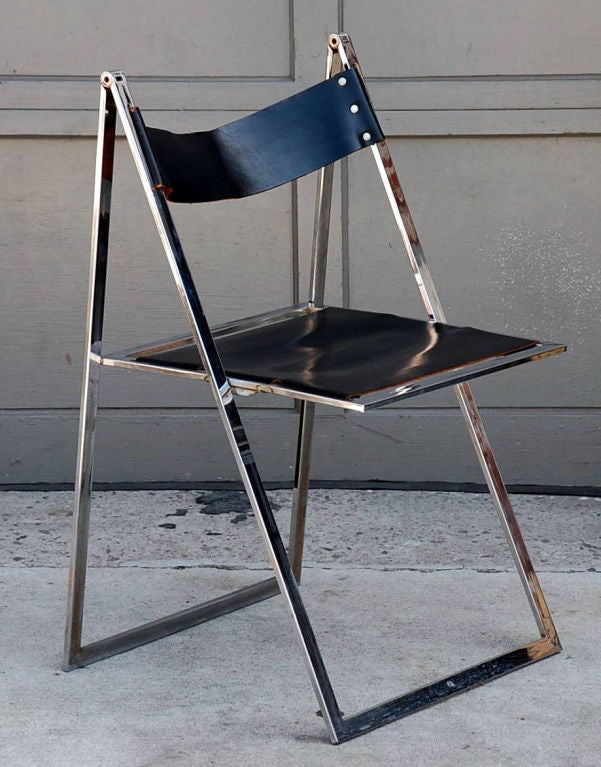 Minimalistic chrome and leather folding chair. Folds into less than one in. thick space. 17 in. seat height.