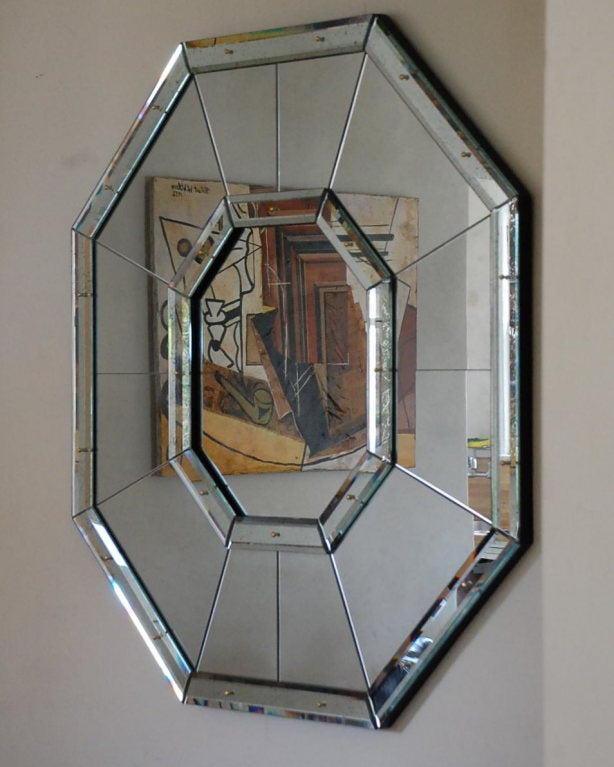 Large 'Octogone' faceted mirror by Design Frères.

A delicate geometric composition alternating clear and antiqued mirror panels framed by overlapping thick beveled mirror baguettes held in place by decorative solid brass screws.

A modern take on