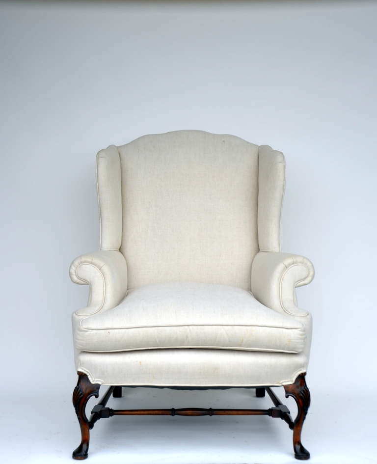 Large comfortable carved wing back chair.