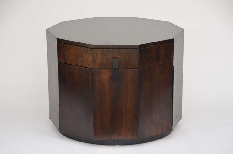 Rare large decagonal walnut bar cabinet by Harvey Probber. Seldomly seen low cabinet with single drawer and piano hinged door with one shelf. Door and drawer are accessed via inverted trapeze pulls. Mounted on a round dark walnut base. Original