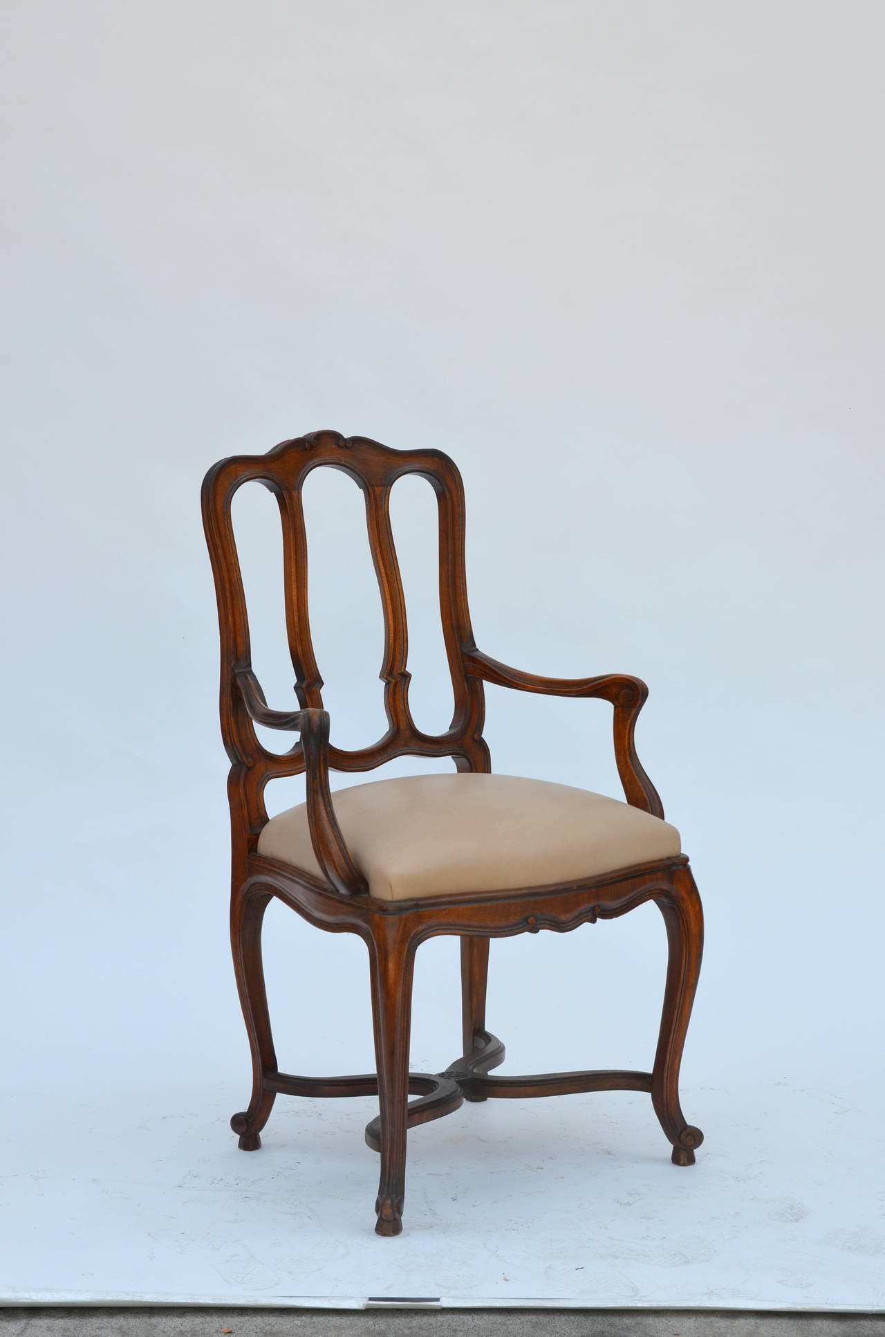 Impressive set of 12 chic French Louis XV style dining chairs and armchairs. Comfortable, sturdy design with new smooth natural leather seats.

Dimensions listed below with armchair arm height at 27 inches.