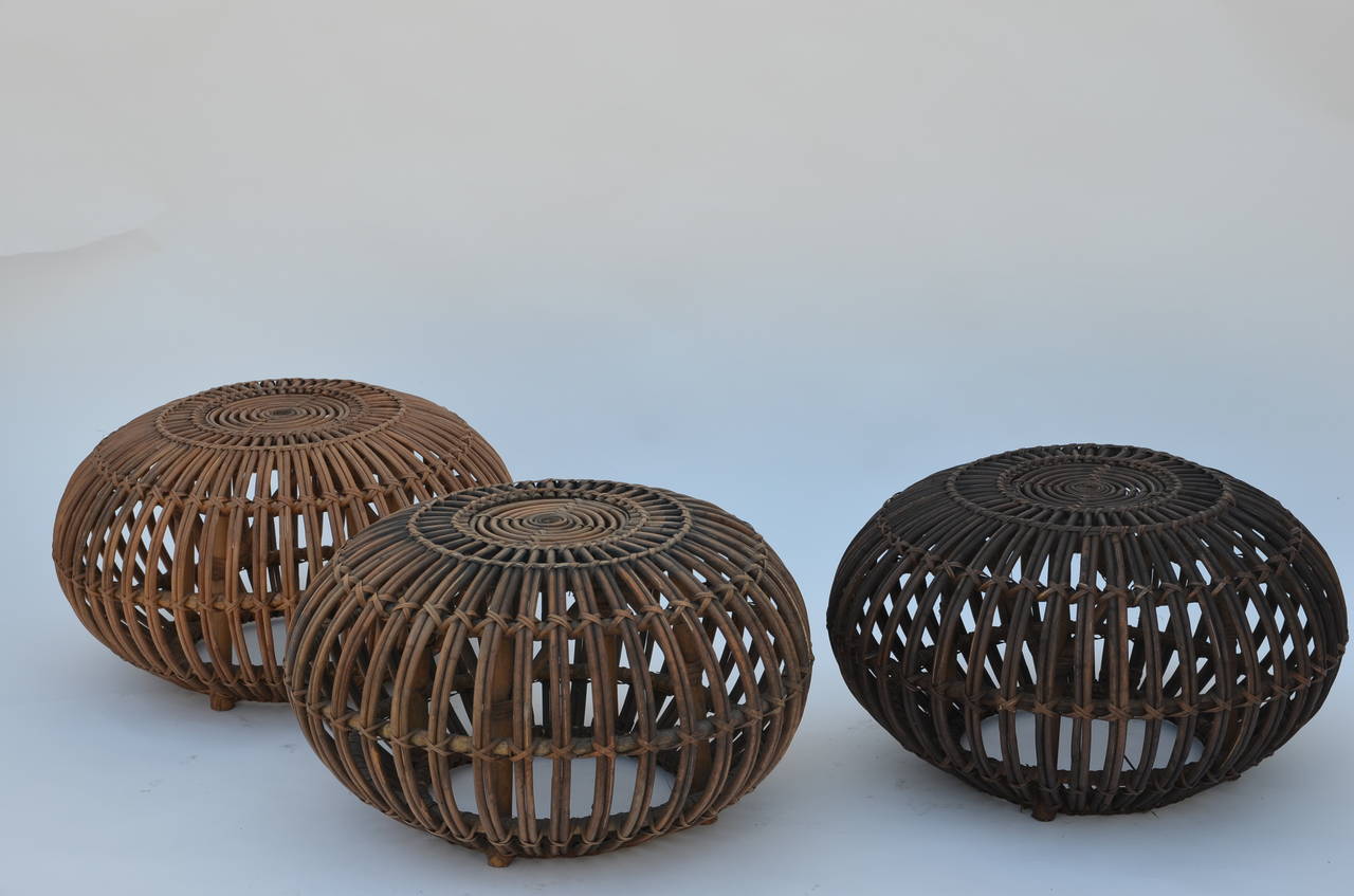 Set of 3 rattan ottomans or stools in the style of Franco Albini. Combination of 3 natural colors: light, medium and dark: very decorative AND functional. Sturdy, solid design.