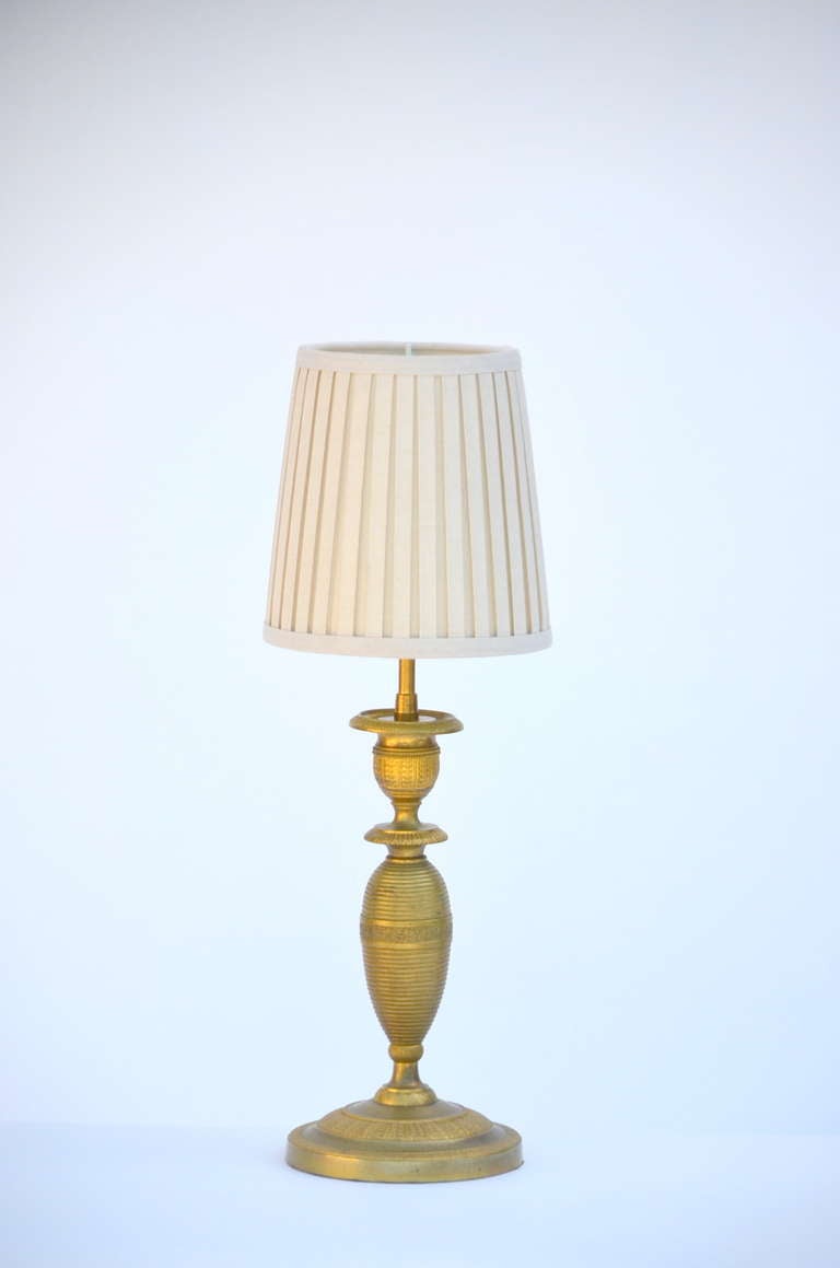 Pair of small gilt bronze table lamps in the style of Armand-Albert Rateau.