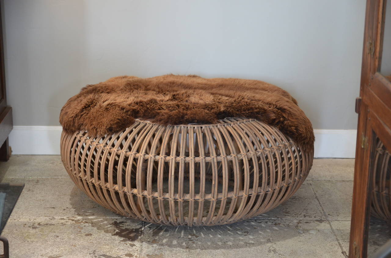Large round rattan ottoman with thick Natural brown fur cover by Franco Albini. Great in the living room or in the bedroom at the base of the bed.