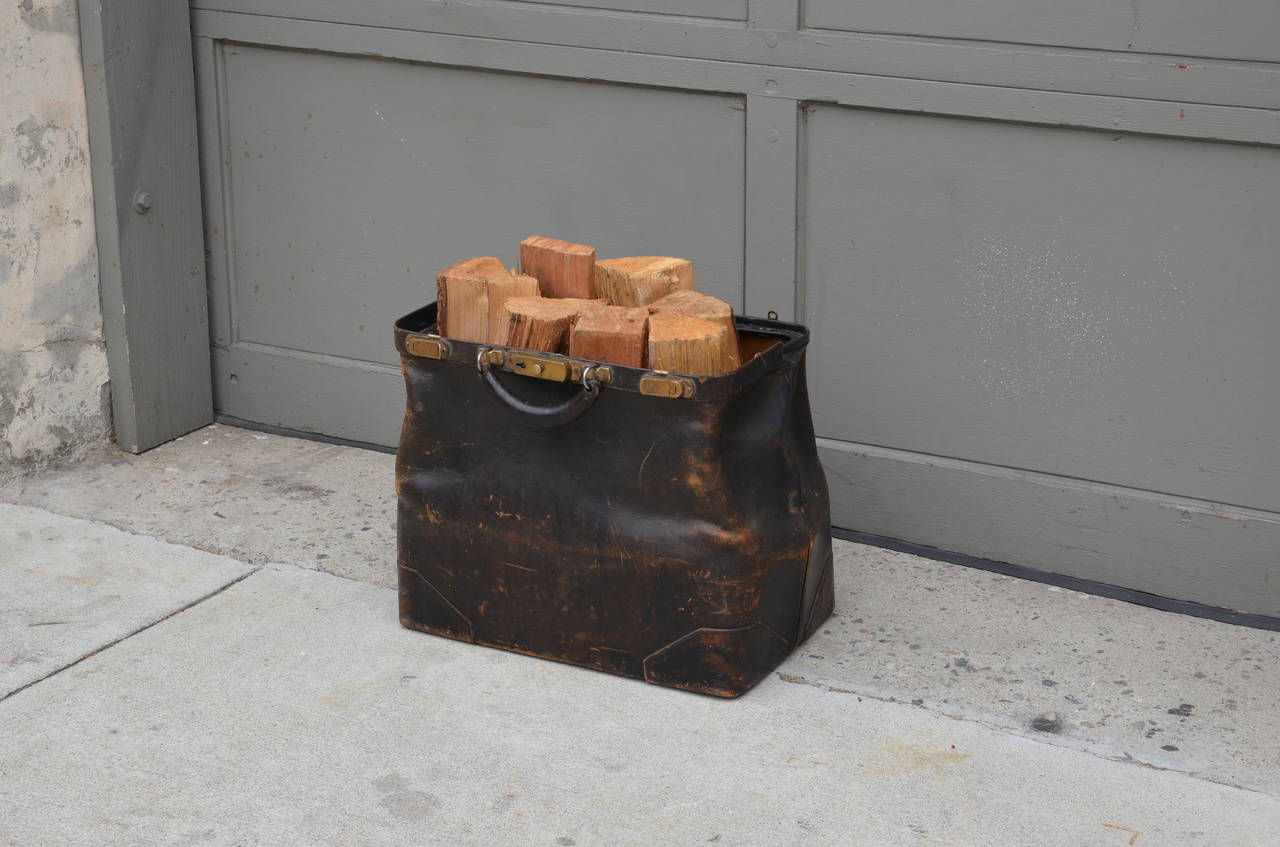 Antique thick leather and brass doctor bag log holder. Great next to a fireplace. Shipping without the wood.