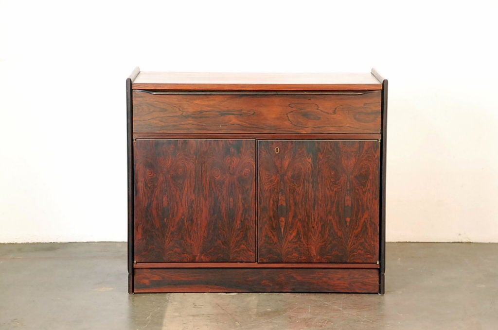 Elegant small rosewood nightstand or cabinet by John Nyquist. Also great as a media cabinet. Functional lock with key included. This cabinet is also designed to be wall-mounted (by easy removal of the base) so the height is adjustable.