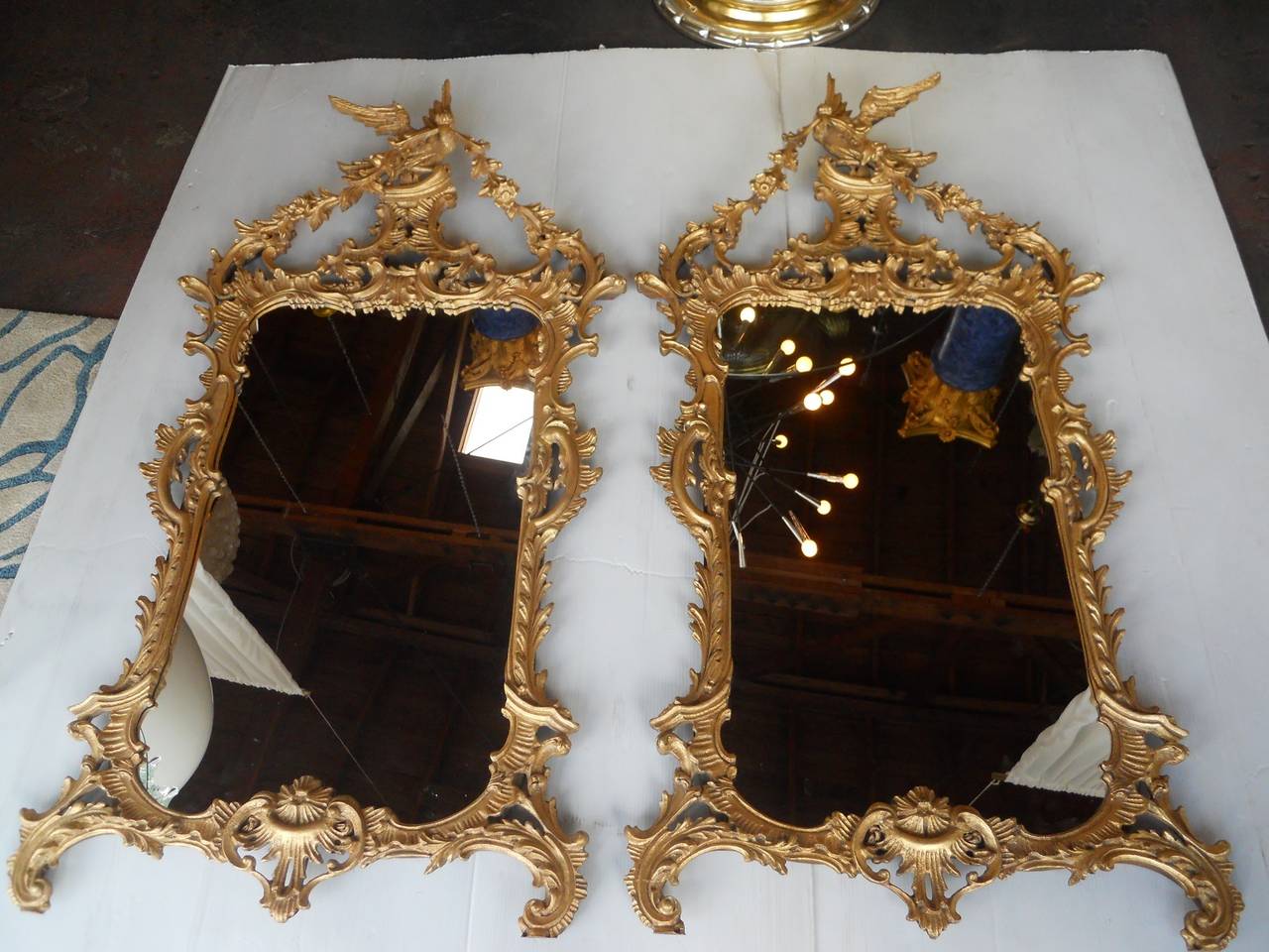 Extraordinary pair of Chippendale style mirrors surmounted by a spread eagle bearing rose flower swags in its beak above an arched cornice,
Hand-carved wood and gold leaf finish.
