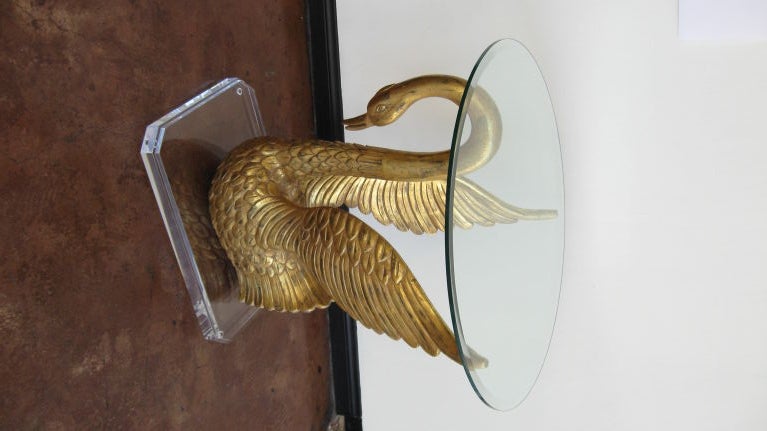 HAND CARVED GOLD LEAFED SWAN SIDE TABLE WITH A LUCITE BASE AND GLASS TOP.