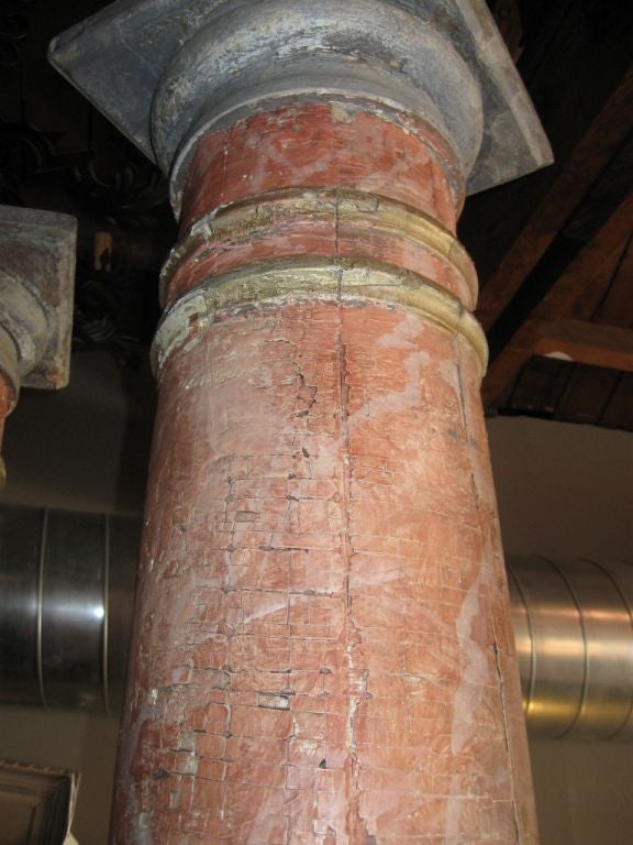 A striking pair of architectural columns in faux terracota. Base is approximately 11 inches in diameter. Top is 12