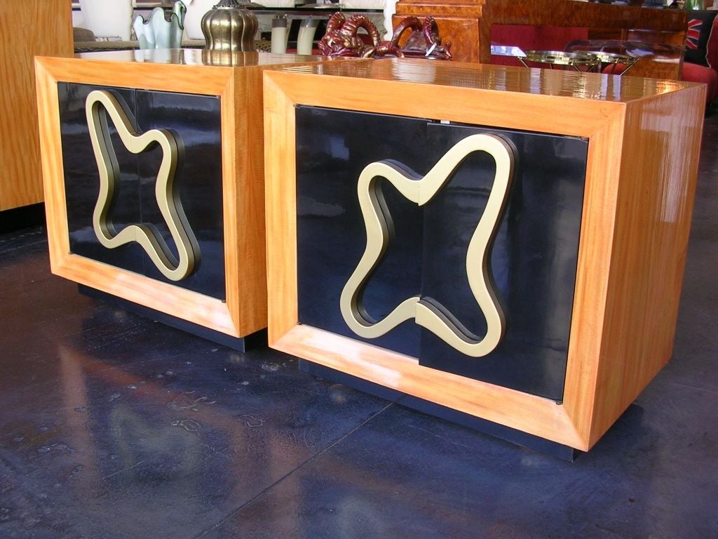 A gorgeous pair of biomorphic designed side tables /nightstands. Made by Popel's, a custom furniture company in Los Angeles. Old label (see photo) is on one of the backs. Satinwood frames have a honey golden brown finish. Interiors have one shelf