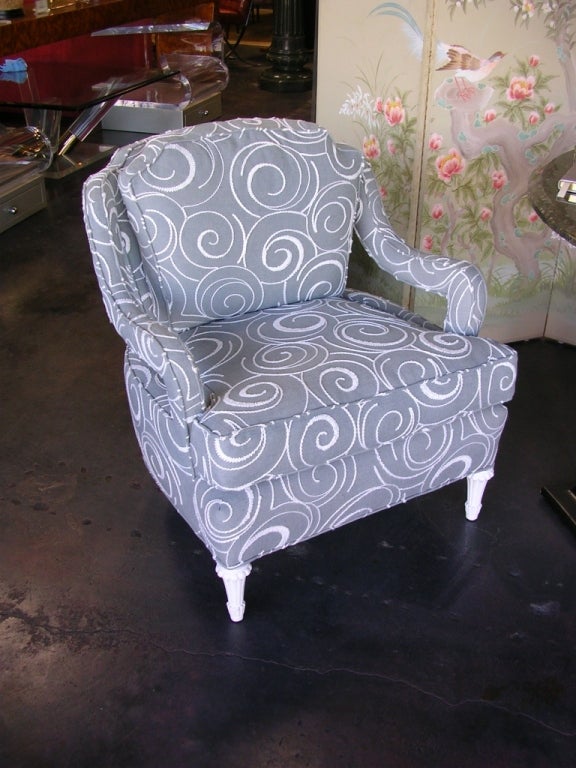A gorgeous pair of Hollywood Regency armchairs. Newly upholstered in a grayish green fabric with white embroidered swirls. Seat height is 19 inches.