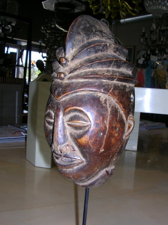 A Punu mask from Gabon. Hand carved wood mounted on a metal stand. Actual mask itself is 4