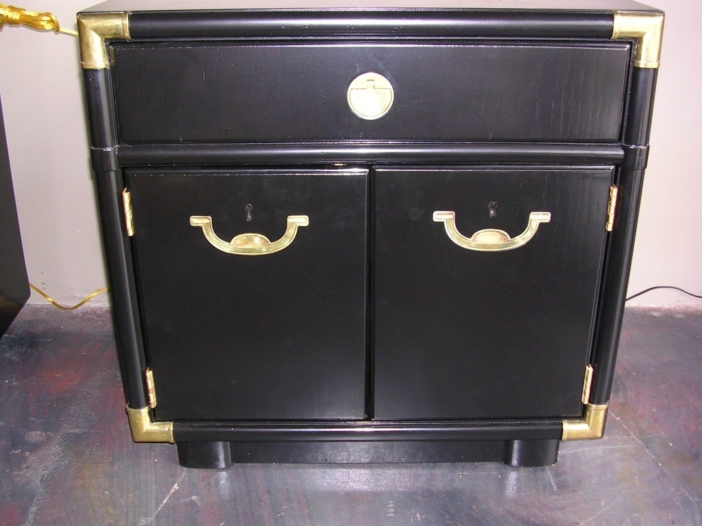 A nice pair of Hollywood Regency faux bamboo nightstands in black lacquer and brass. Brass handles have the cool feature of being recessed into the wood. Handles flip out. These were made by Drexel and have the labels inside the drawers. Has one top