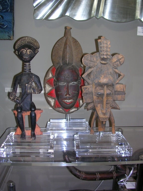 A set of three unique African wood carvings -- two masks and one mother and child sculpture. All are mounted on stepped Lucite bases. Price is for all three pieces. Can be purchased separately for $400 each.

Sizes are as follows:
Mother and Child -