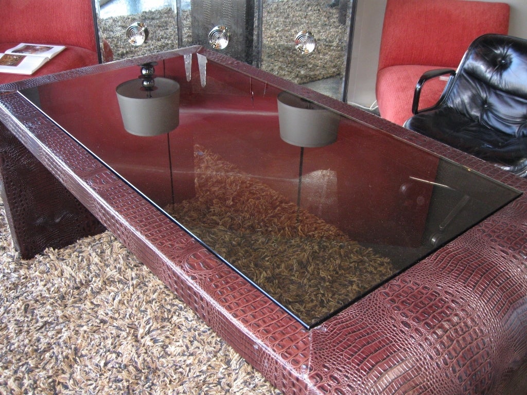 A faux alligator clad leather desk. Leather was hand sewn and sheathed into a wood frame. Center is bronzed glass. Note leg clearance is 27 1/2 inches.