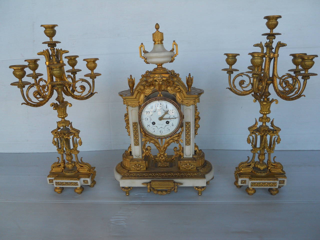 French 19th century clock set
1 clock and 2 candelabras made of marble and gilt bronze
marked: Medaillos d'Or
The dimensions below are for the clock
dimensions for each candelabra: 22.5