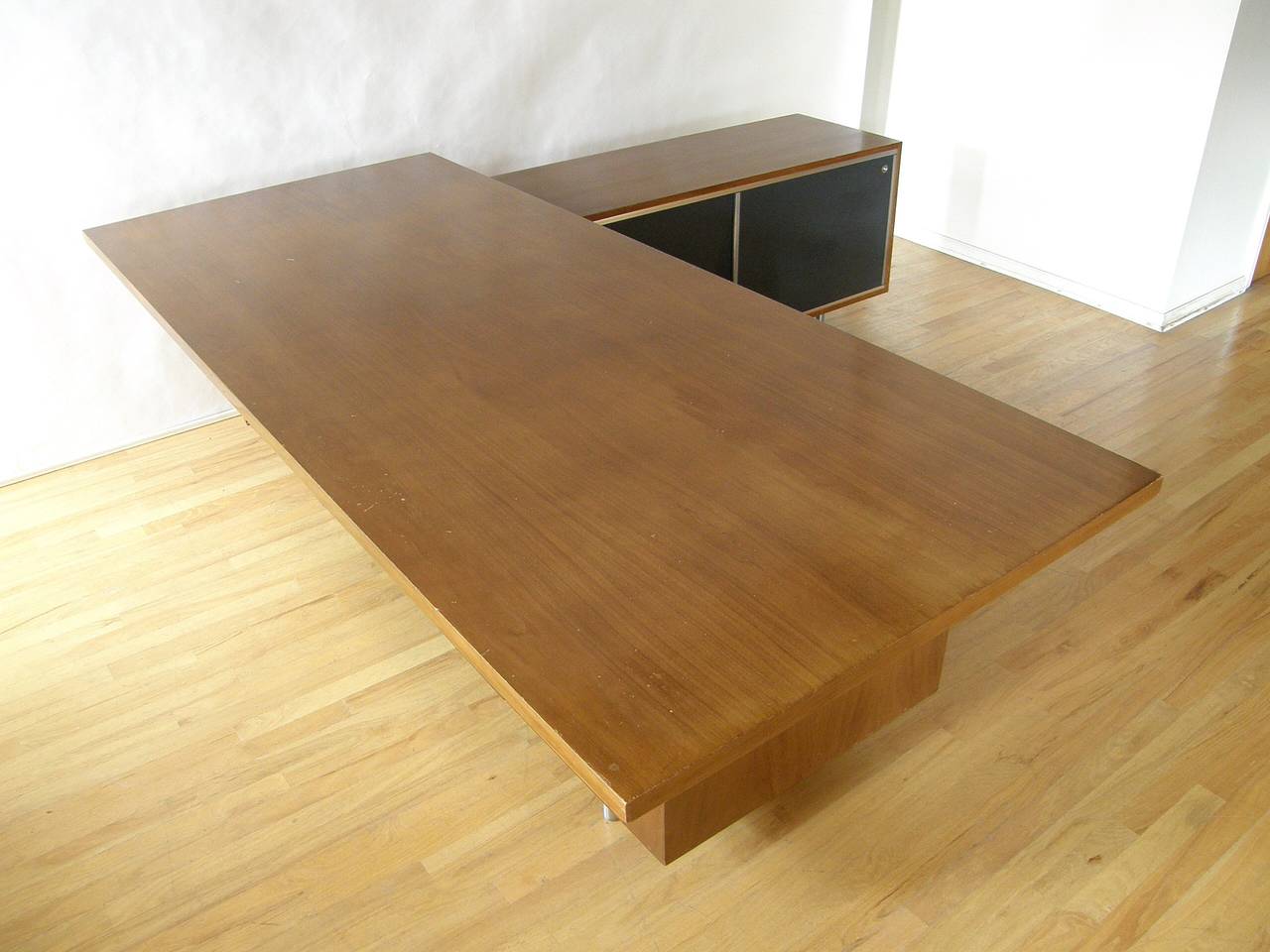 Sprawling executive desk with return by George Nelson for Herman Miller. In addition to the storage in the desk drawers and the return, it features a cane modesty panel and the rare waste basket storage space with the spring-loaded lid built into