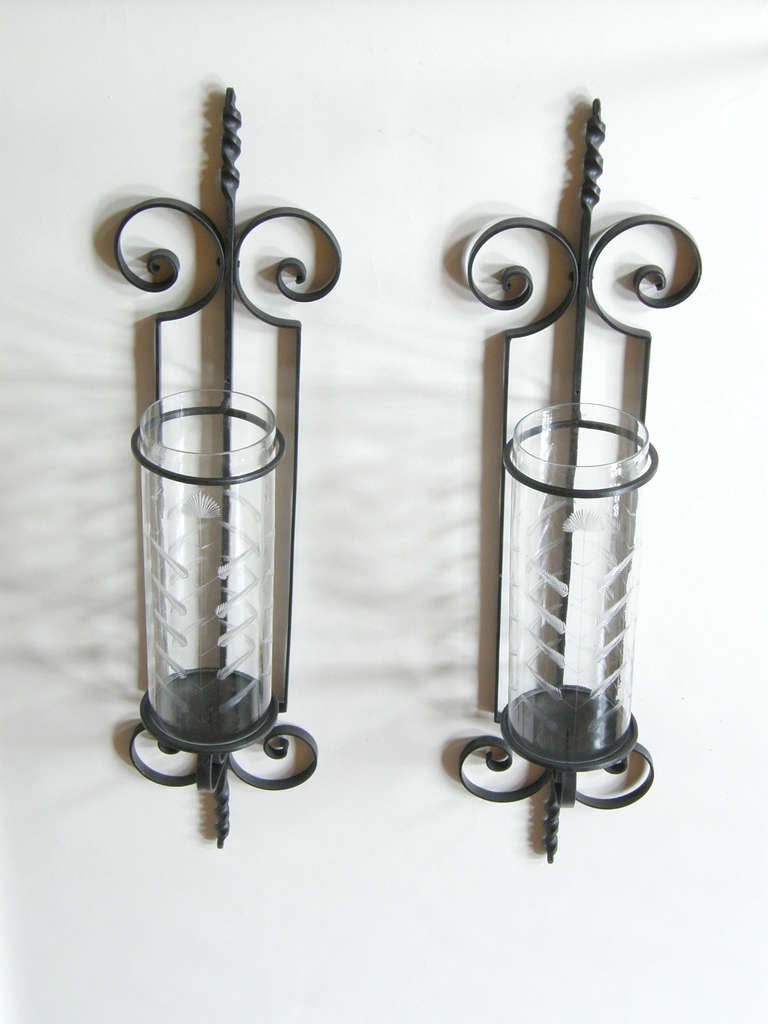 These monumental, wall mounted, hurricane candle sconces have a twisting and scrolling wrought iron framework and glass cylinder shades with an etched leaves pattern.

Please contact us if you have any questions.