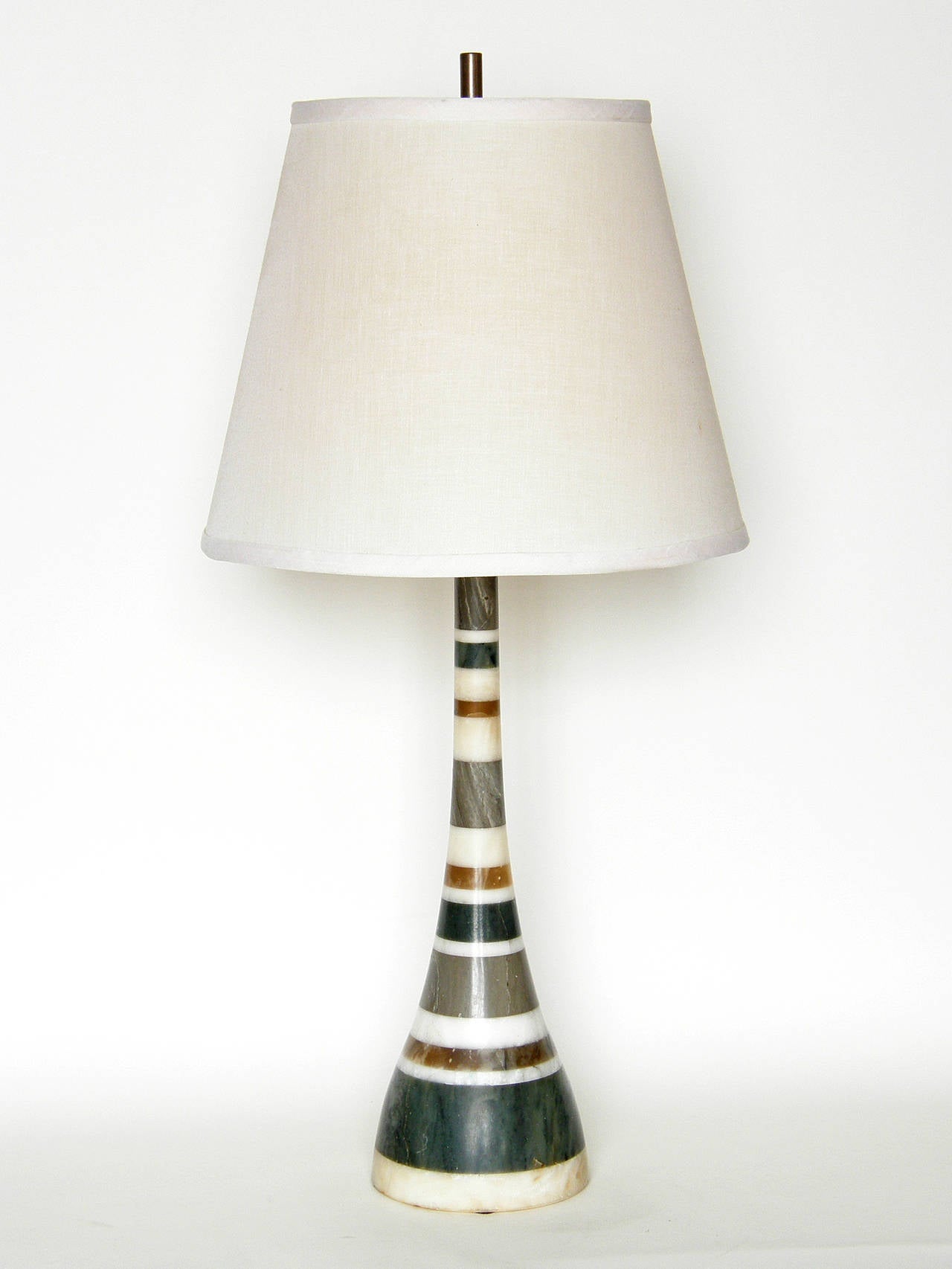 Italian lamp with wide base and tapering neck. The varied thickness of the multi-colored stone stripes add a playful quality to the simple, modern lines of the form. It may be made of different types of stone. 

approximate measurements:
base-