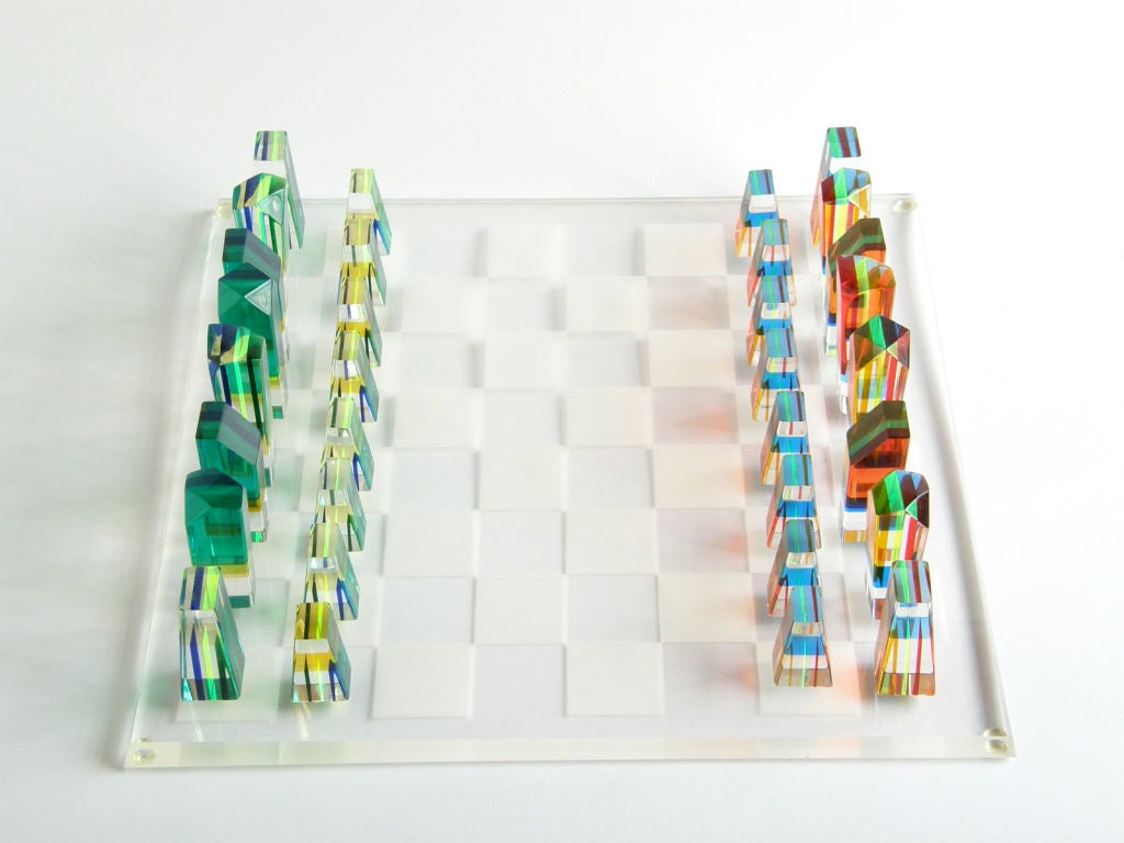 Great Op-Art chess set with abstract, sculptural shapes. The pieces are cut from blocks of clear acrylic with thin layers of translucent color. From the ends they appear as thin colored stripes. As you move the piece around, the layers of color