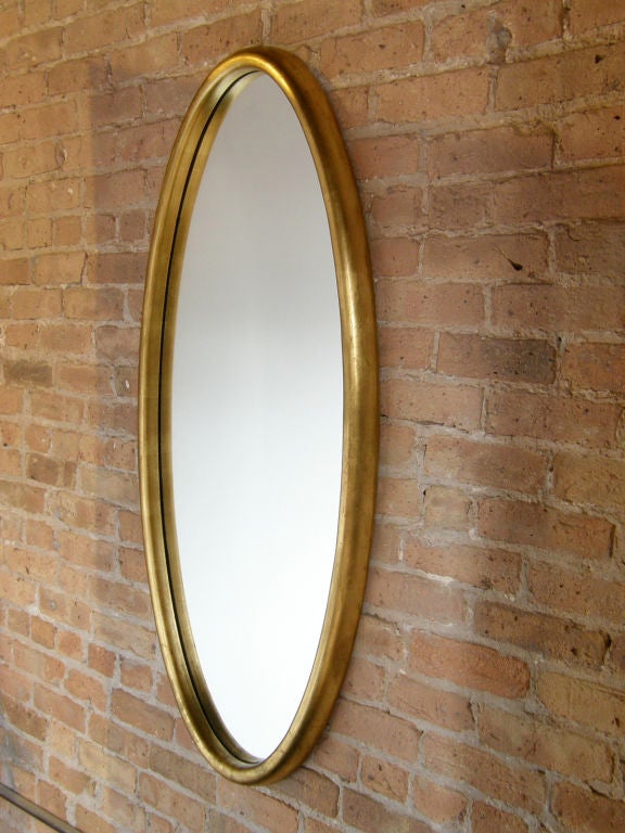 Large oval mirrror, wood frame with antiqued gilt finish.
