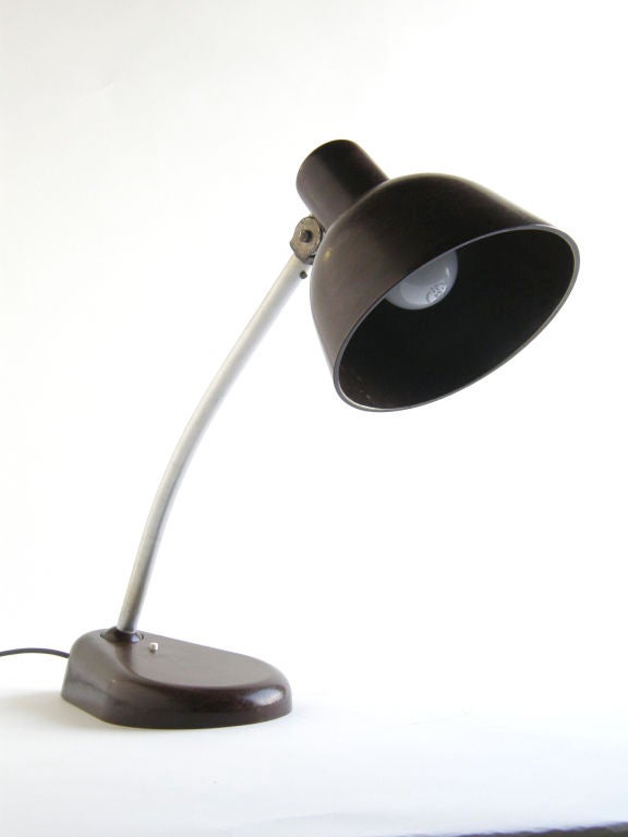 Nice, circa 1930s, modernist style desk lamp in Bakelite and aluminum. The arm pivots on a ball and socket joint, and the shade adjusts its position on the arm. This is a nice example of machine age industrial design in lighting. No manufacturer's