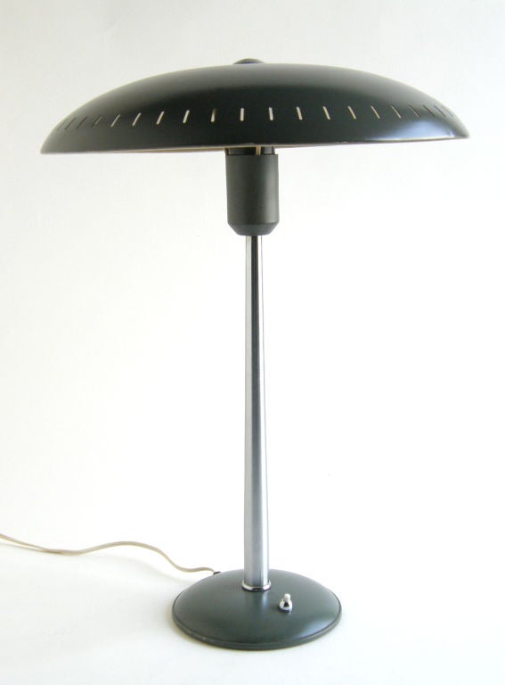Table lamp with open top and perforated metal shade designed by Louis Kalff for Philips, Netherlands. This lamp has pleasing proportions, and an elegantly tapered stem.

Please contact us if you have any questions.